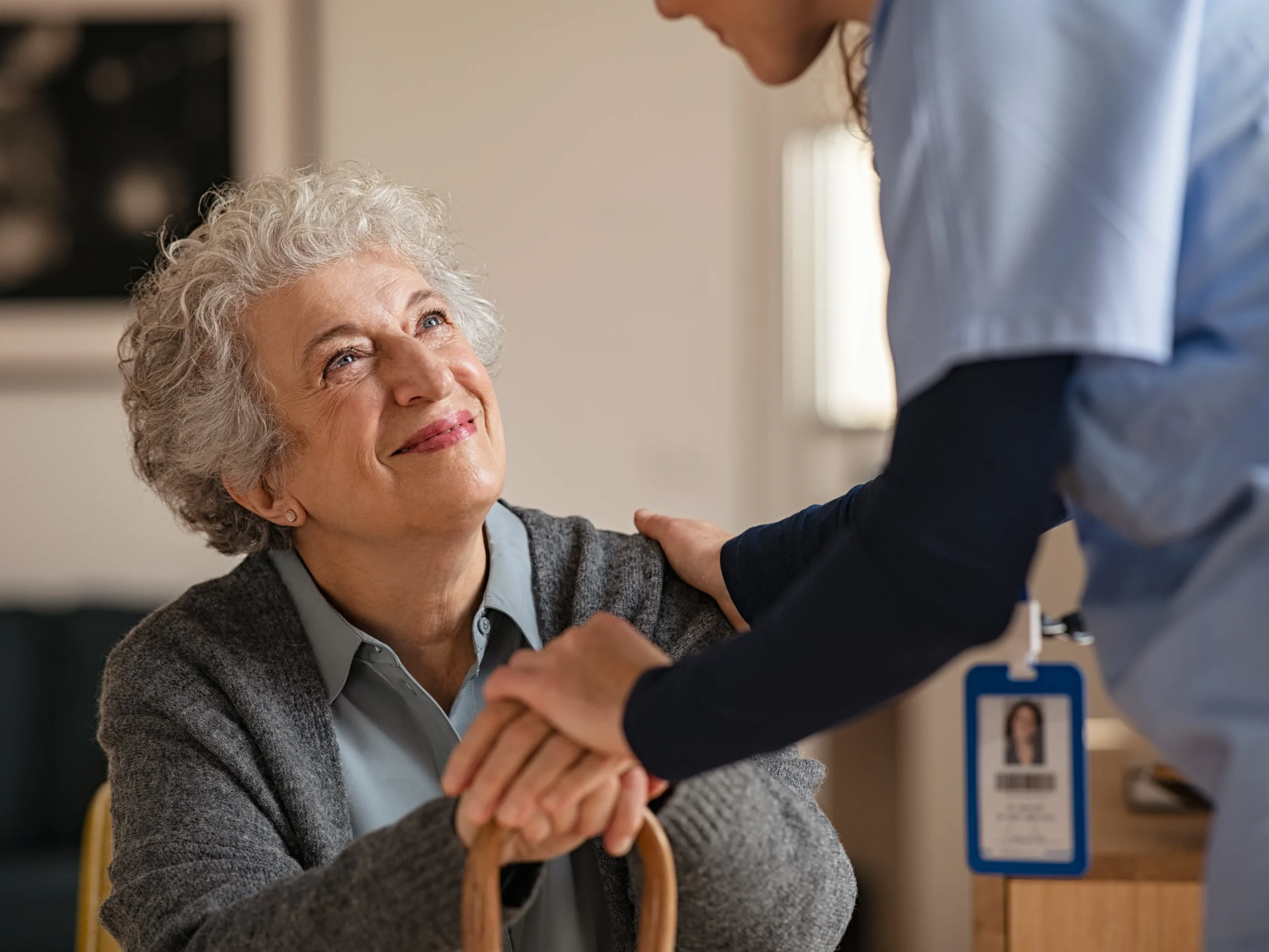 elderly woman smiling at nurse who is external support for elderly care